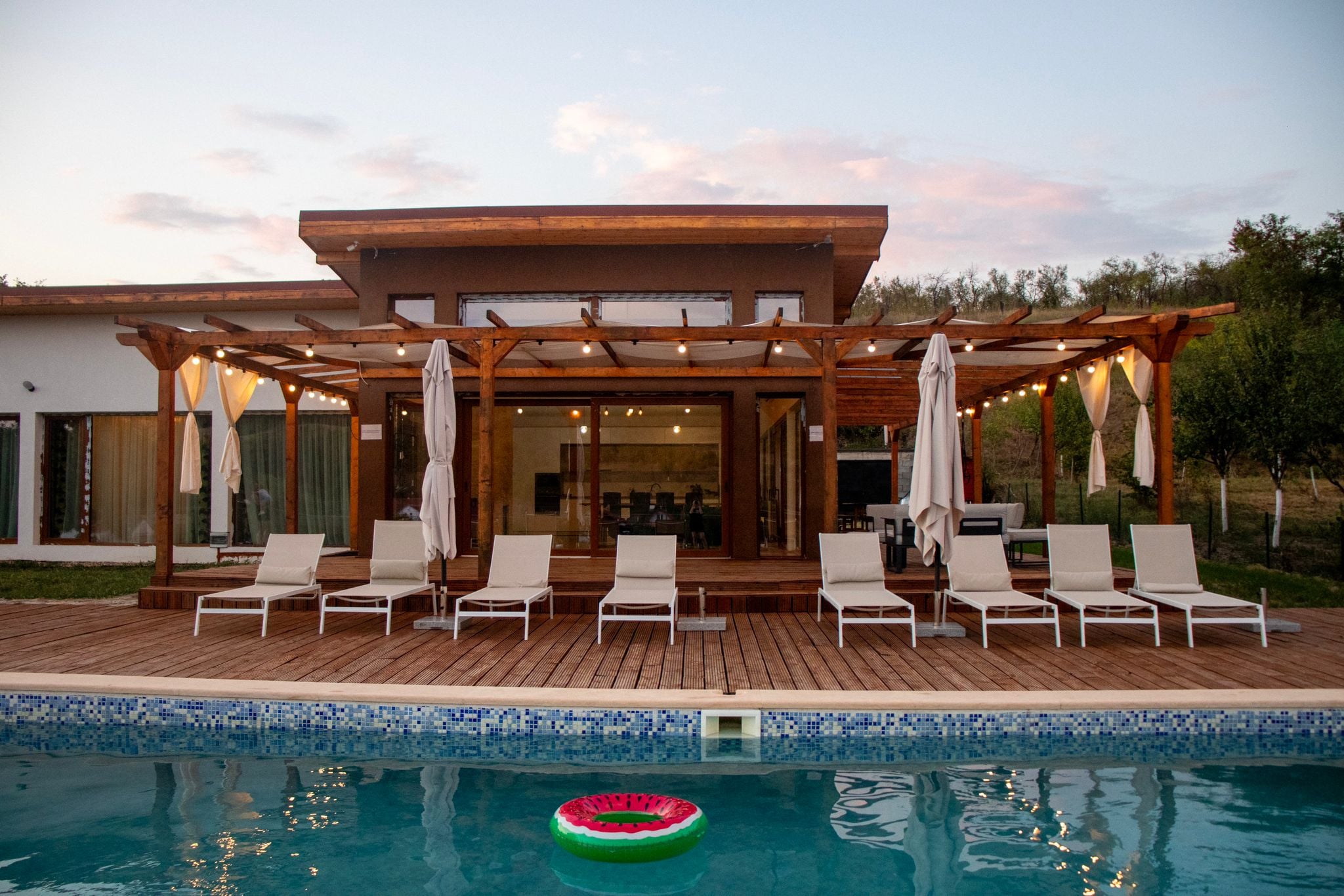 Zonă piscină cu șezlonguri și deck pentru zile de naștere și petreceri